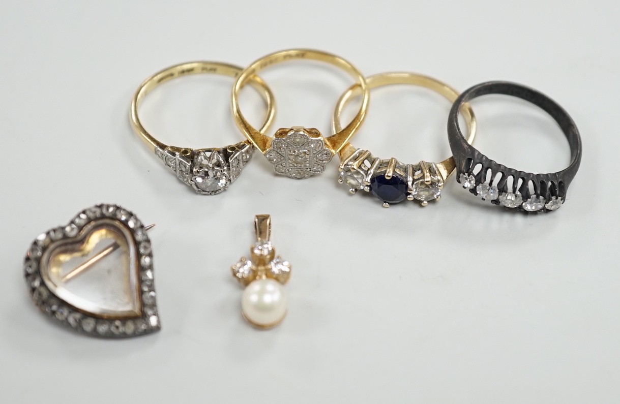 An 18ct, plat and single stone diamond ring, with diamond set shoulders, size O, a similar diamond cluster ring, size N, a blackened? 18ct gold and five stone diamond ring, a late Victorian diamond set heart shaped mourn